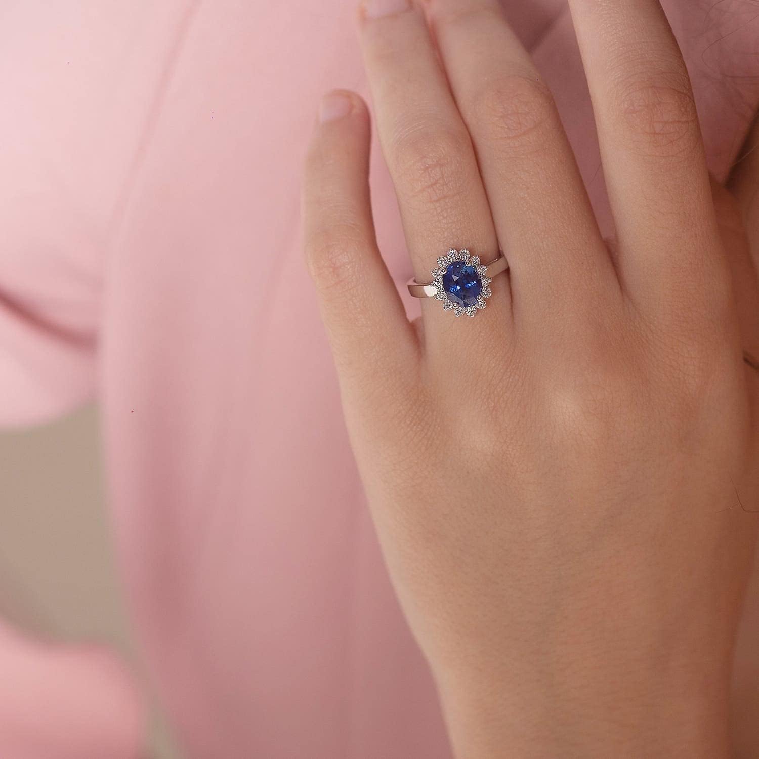Blue sapphire halo ring in 14K gold and platinum with romantic princess Diana inspired design
