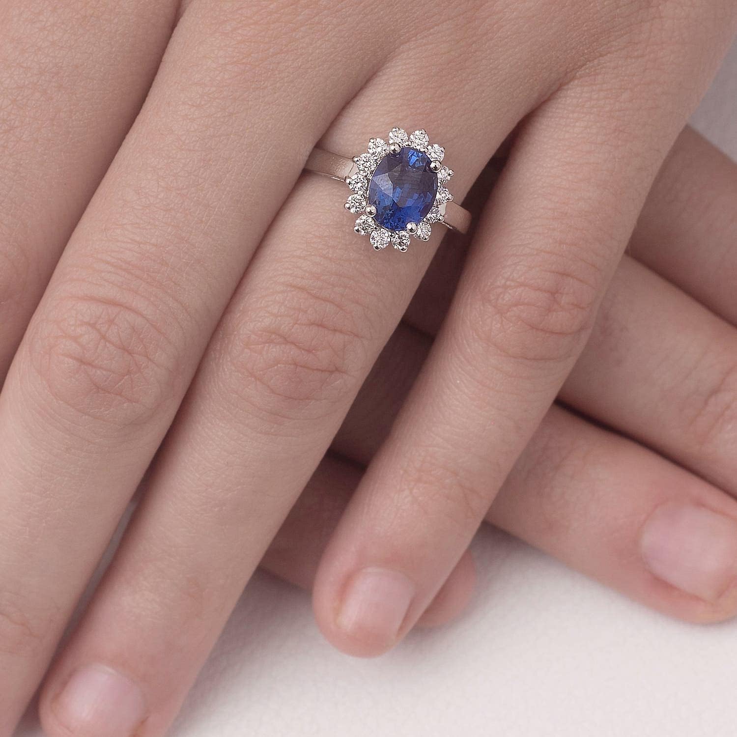 Blue sapphire halo ring in 14K gold and platinum with romantic princess Diana inspired design